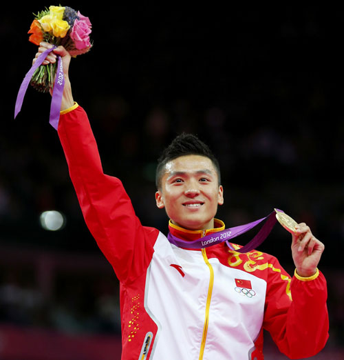 Dong Dong of China celebrates with his gold medal at the men's gymnastics trampoline final in the North Greenwich Arena