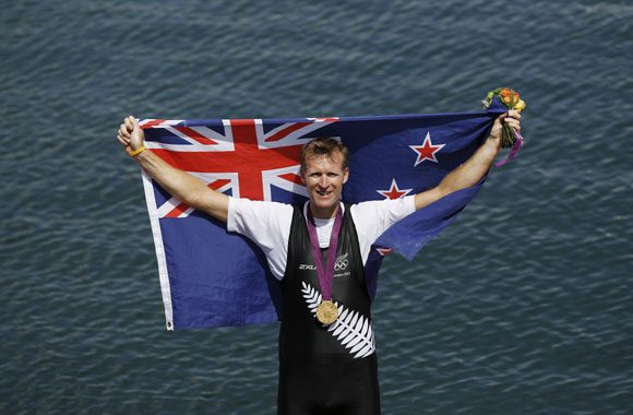 Gold medallist Mahe Drysdale of New Zealand holds up his national flag after the Men's Single Sculls Final event