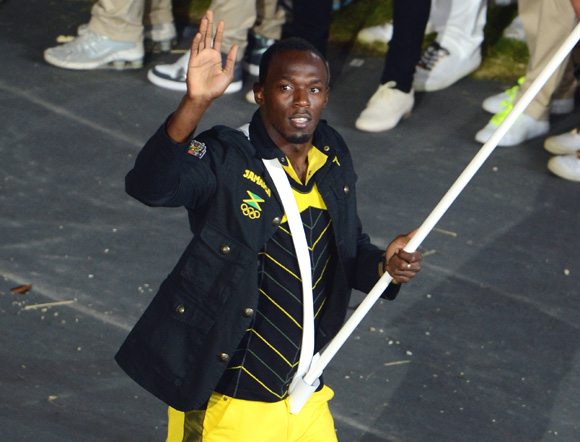 Reigning Olympic Men's 100m and 200m champion Usain Bolt of the Jamaica Olympic athletics team carries his country's flag during the Opening Ceremony of the London Games