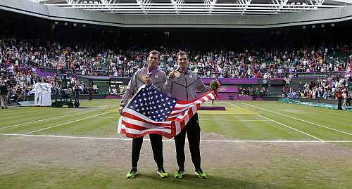 Gold medalists Mike Bryan, right, and Bob Bryan, left, of the United States, pose with the U.S. national flag after the medal ceremony of the men's doubles final match