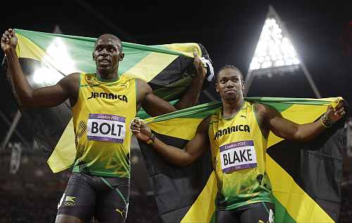Jamaica's Usain Bolt, left, celebrates winning gold alongside silver medallist Yohan Blake of Jamaica following the men's 100-metre final