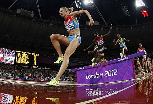 Russia's Yuliya Zaripova, left, goes to land in the water pit as she competes to win gold in the women's 3000-meter steeplechase final