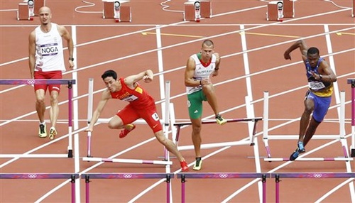 China's Liu Xiang, second left, falls as Hungary's Balazs Baji, Poland's Artur Noga and Barbados' Shane Brathwaite react during a men's 110-meter hurdles heat