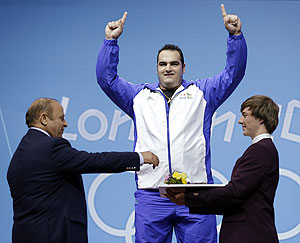 Gold medalist Behdad Salimikordasiabi of Iran on the podium after winning the men's over 105-kg, group A, weightlifting competition on Tuesday