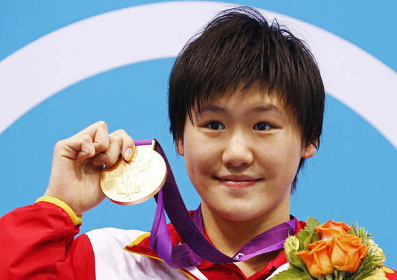 China's Ye Shiwen poses with her gold medal on the podium during the women's 400m individual medley