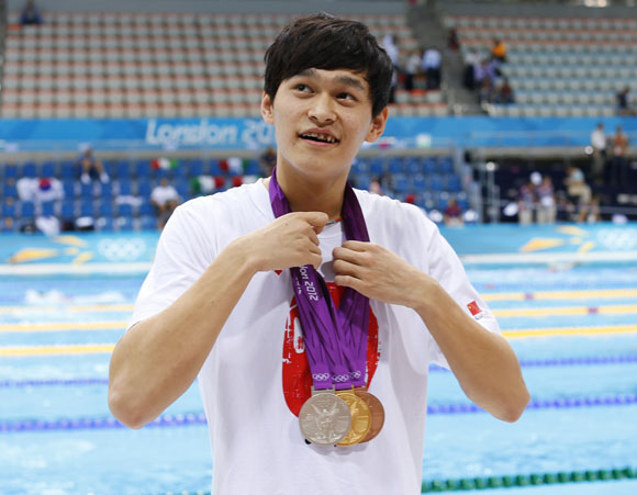 China's Sun Yang, wearing his medals, arrives for the evening finals swimming session