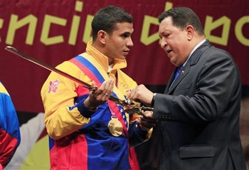 Venezuela's President Hugo Chavez, right, presents a replica of a sword once used by   South American independence hero Simon Bolivar to Venezuela's fencer Ruben Limardo
