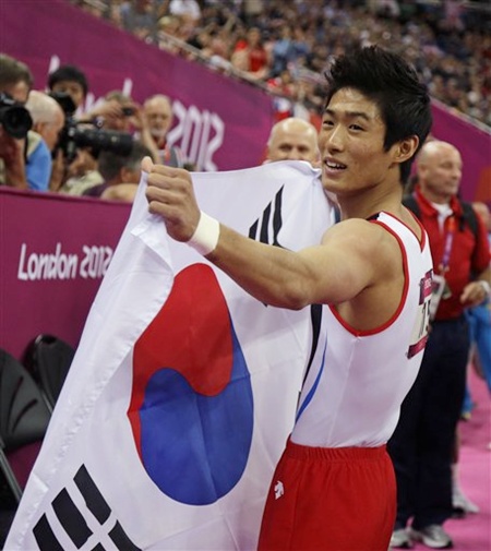South Korean gymnast Yang Hak-seon holds his national flag