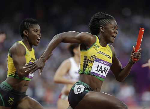 Jamaica's Kerron Stewart gets the baton from her teammate Schillonie Calvert, left, in a women's 4x100-meter relay