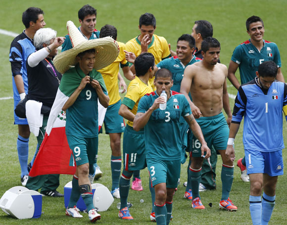 Mexico's double goalscorer Oribe Peralta (front L) wears a sombrero hat and a national flag while celebrating with team mates after their victory over Brazil in their men's soccer final