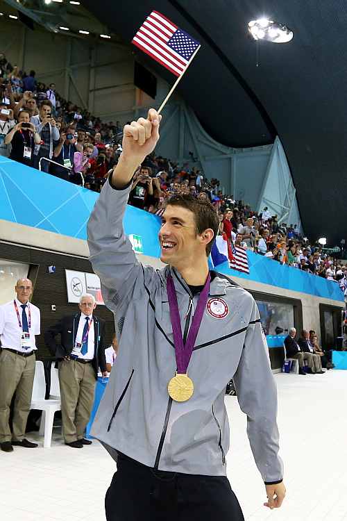 Gold medallist Michael Phelps of the United States waves a United States national flag following the medal ceremony