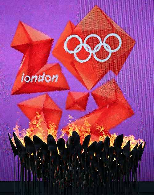 The Olympic Cauldron burns in front of the London 2012 logo