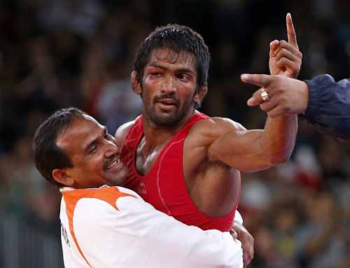 India's Yogeshwar Dutt (in red) reacts after defeating for the bronze medal North Korea's Jong Myong Ri