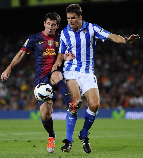 Lionel Messi of FC Barcelona (left) duels for the ball with Ion Ansotegi Gorostola of Real   Sociedad