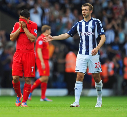 Luis Suarez of Liverpool is consoled by Gareth McAuley of West Brom