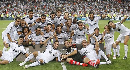 Real Madrid's players celebrate with the trophy after winning their Spanish Super Cup second leg match against Barcelona at the Santiago Bernabeu stadium on Wednesday
