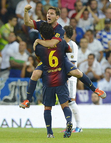 Barcelona's Lionel Messi (top) celebrates with teammate Xavi after scoring against Real Madrid during their Spanish Super Cup second leg match on Wednesday