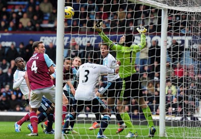 Petr Cech of Chelsea saves from the headed of Winston Reid of West Ham United during the Barclays Premier League match between West Ham United and Chelsea at the Boleyn Ground