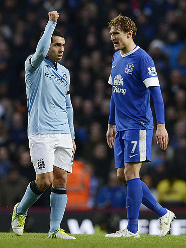 Manchester City's Carlos Tevez (left) celebrates after scoring as Everton's Nikica Jelavic looks on during their English Premier League match on Saturday