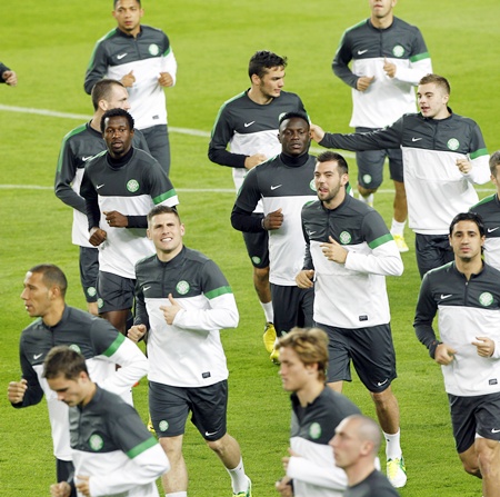 Celtic's players warm up during a training session