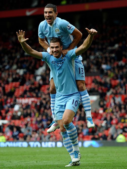 Edin Dzeko of Manchester City celebrates scoring his team's sixth goal with team mate Aleksandar Kolarov