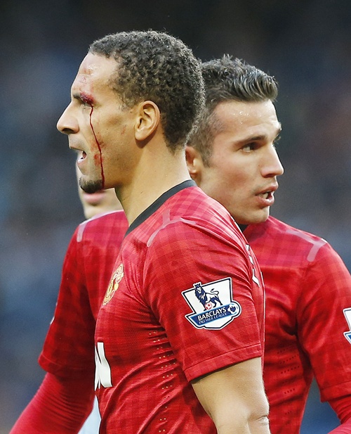 Manchester United's Rio Ferdinand (left) is helped from the pitch by teammate Robin van Persie
