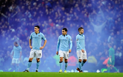 Carlos Tevez of Manchester City and team-mate Gareth Barry look dejected