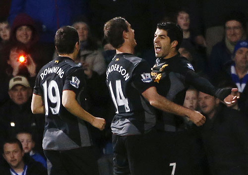 Liverpool's Luis Suarez (right) celebrates with teammates after scoring against Queens Park Rangers during their English Premier League match on Sunday