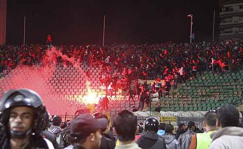 Soccer fans flee from a fire at Port Said Stadium