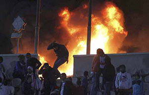 A soccer fan flees from a fire at Cairo stadium