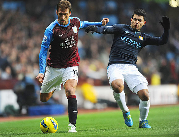 Aston Villa's Stiliyan Petrov is tackled by Man City's Sergio Aguero