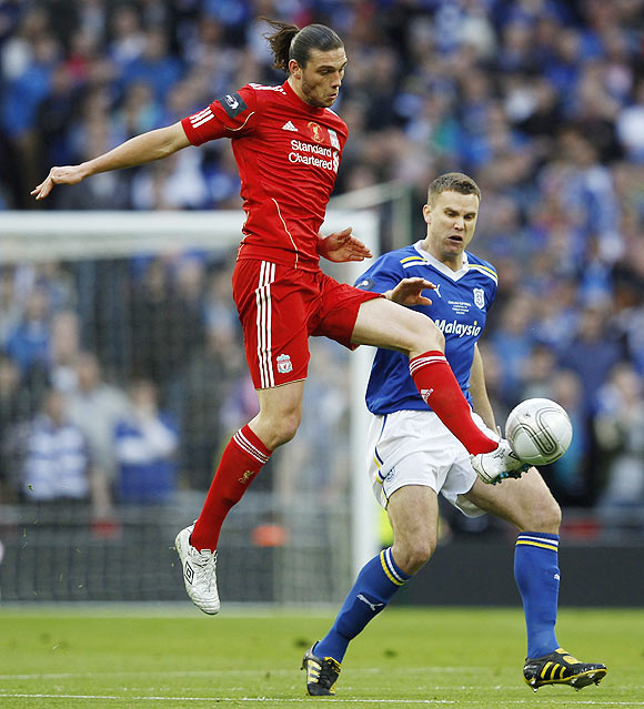 Liverpool's Andy Carroll (left) challenges Cardiff City's Ben Turner