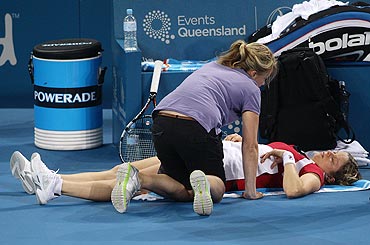 Kim Clijsters lies on the floor after a hip injury during the Brisbane Open