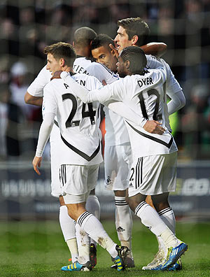 Scott Sinclair of Swansea City is congratulated by teammates after scoring his penalty against Arsenal on Sunday