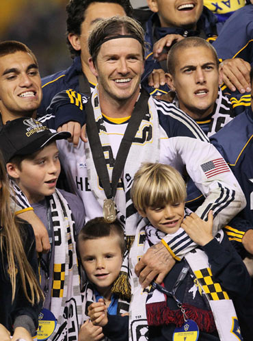 David Beckham #23 of the Los Angeles Galaxy celebrates with his sons Brooklyn, Cruz and Romeo after defeating the Houston Dynamo 1-0 in Carson, California
