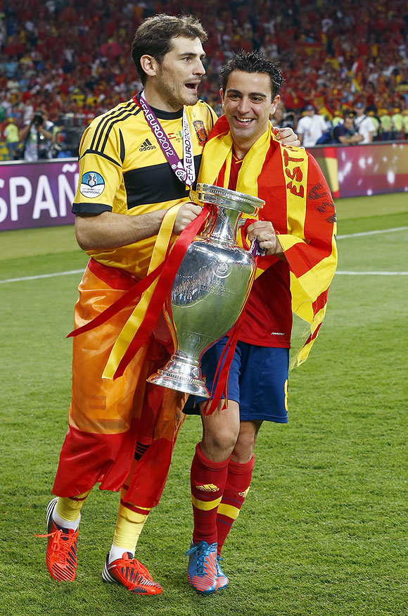 Spain's goalkeeper and captain Iker Casillas and Xavi Hernandez (right) celebrate with the trophy after defeating Italy