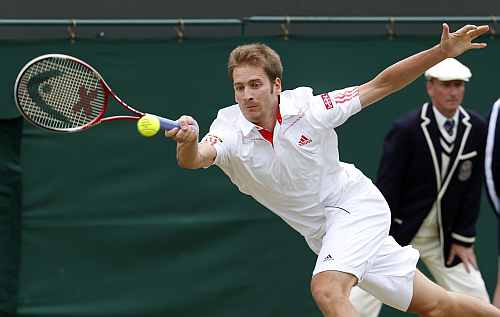 Florian Mayer of Germany hits a return to Richard Gasquet of France during their men's singles tennis match at the Wimbledon