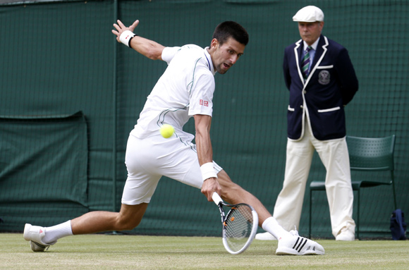 Novak Djokovic of Serbia hits a return to Florian Mayer of Germany during their men's quarter-final tennis match at the Wimbledon tennis championships in London