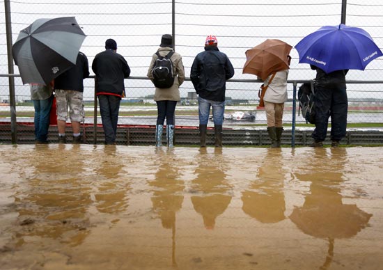 Fans watch in wet and muddy conditions during practice for the British Grand Prix