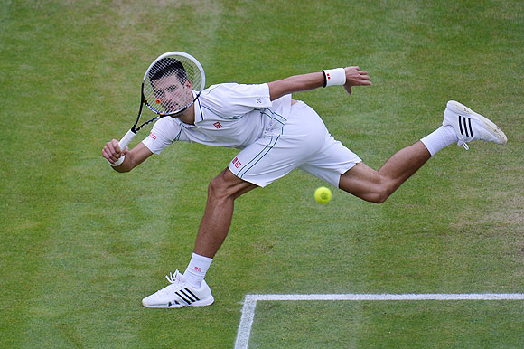 Novak Djokovic hits a return against Roger Federer