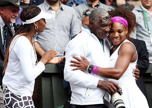 Serena Williams celebrates with her father Richard Williams and sister Venus Williams after her Wimbledon final win over Agnieszka Radwanska