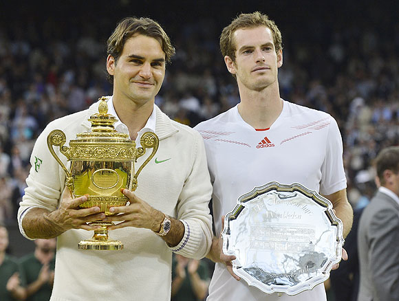 Roger Federer holds his winners trophy and Andy Murray with his runners-up trophy after the Wimbledon final on Sunday