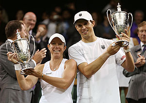 Mike Bryan and Lisa Raymond hold up the winners trophy after beating Elena Vesnina and Leander Paes to win the Mixed Doubles final on Sunday