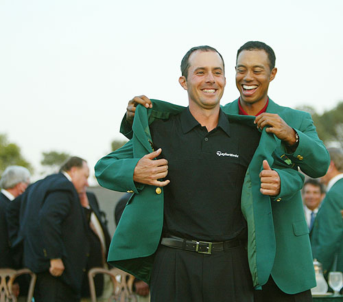 Canadian golfer Mike Weir receives his green jacket from former champion Tiger Woods