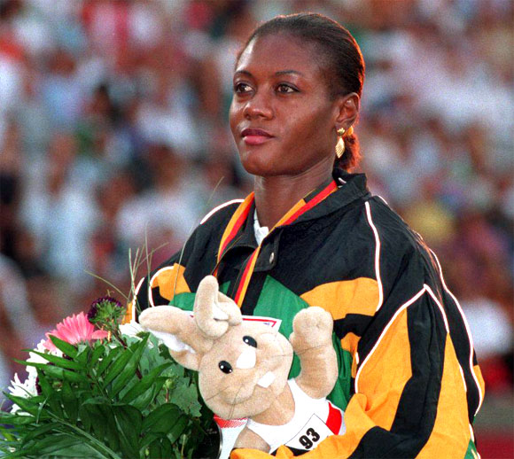 Merlene Ottey of Jamaica stands on the podium with her silver medal during the medal ceremony