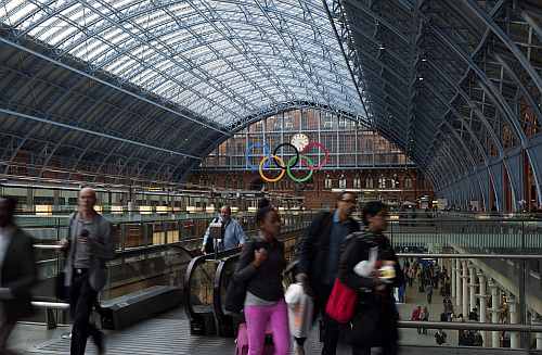 The Olympic Rings are seen as commuters walk in St Pancras Station in London
