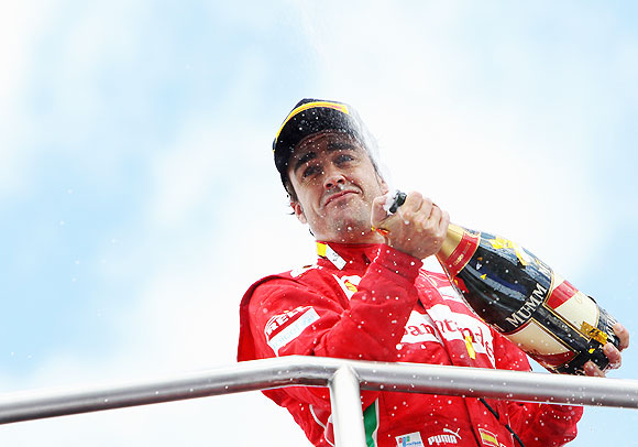 Fernando Alonso of Spain and Ferrari celebrates on the podium