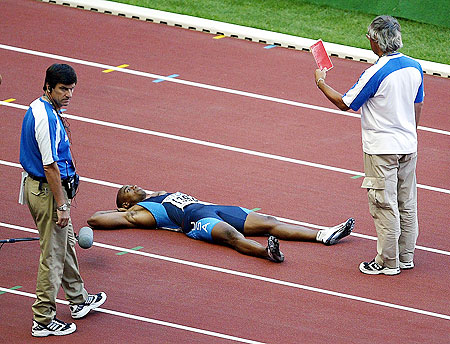 Jon Drummond of the USA lies on the track in protest after being disqualified for a false start