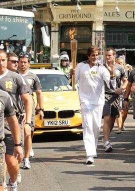 Amitabh Bachchan carries the Olympic Flame on the Torch Relay leg between The City of London and Southwark during Day 69 of the London 2012 Olympic Torch Relay