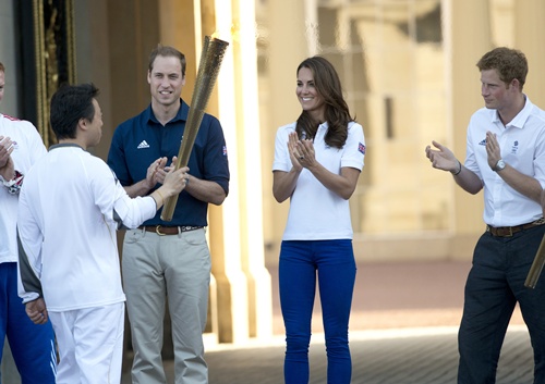 Catherine, Duchess of Cambridge, Prince William, Duke of Cambridge and Prince Harry applaud Wai-Ming as the Olympic Torch comes to Buckingham Palace